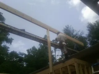 Carpenter setting a ridge beam over a new addition frame — Ice Dam Removal by Roofing Brothers in Cheltenham