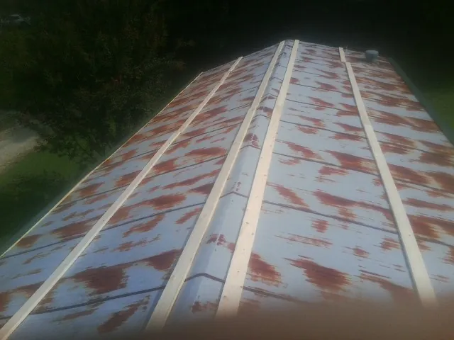Rusted metal roof panels with new wood purlins before replacement — Storm Damage Roof Repair in Cheltenham by Roofing Brothers