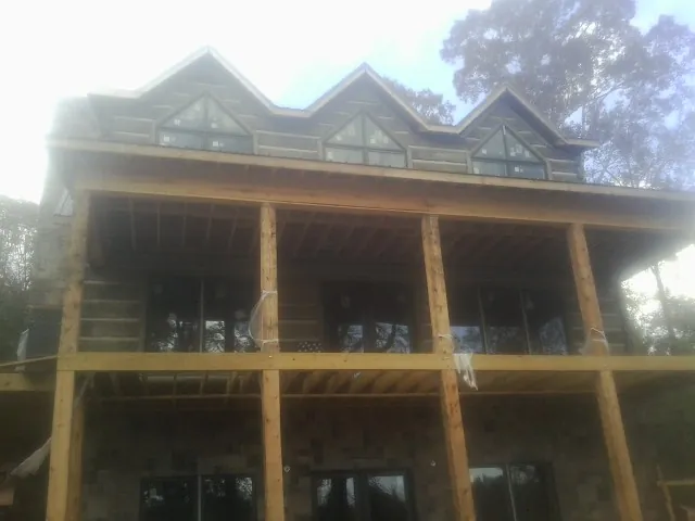 Dormers and porch framing on a large log home under construction — Roof Coating work by our crew in Cheltenham
